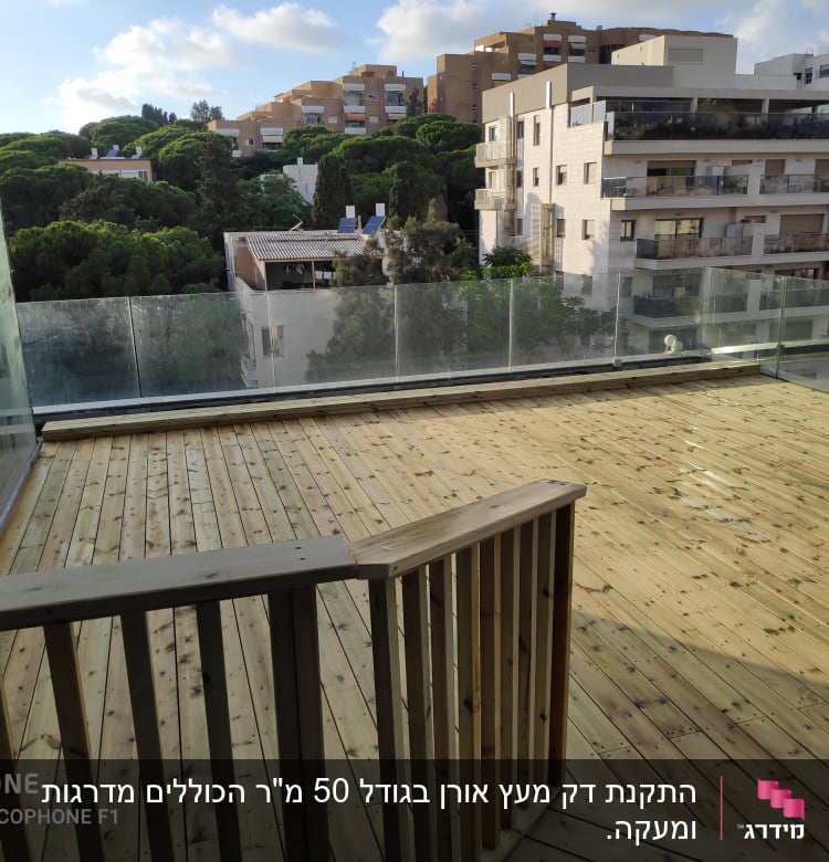 מרפסת עץ עם מעקה זכוכית ונוף עירוני